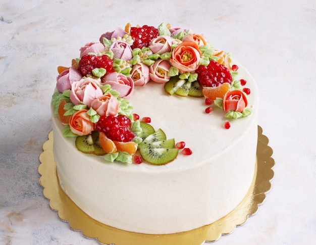Pastel festivo con crema de flores y frutas en una luz
