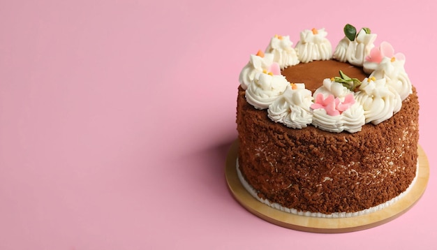 Un pastel con flores sobre un fondo rosa.