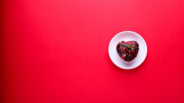 Pastel en forma de corazón sobre un fondo rojo. Día de San Valentín.