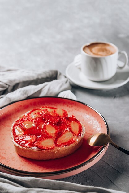 pastel con fresas y una taza de café