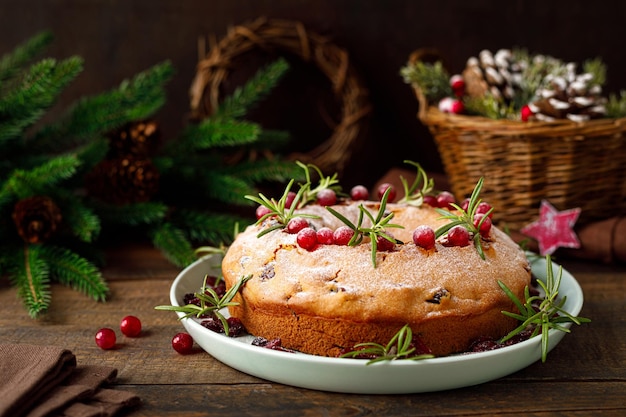 Pastel de frutas de arándano de Navidad con decoraciones sobre fondo de madera