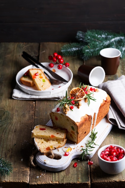 Pastel de frutas espolvoreado con glaseado, nueces, granos de granada y primer plano de naranja seca. Pastel casero de Navidad e Invierno