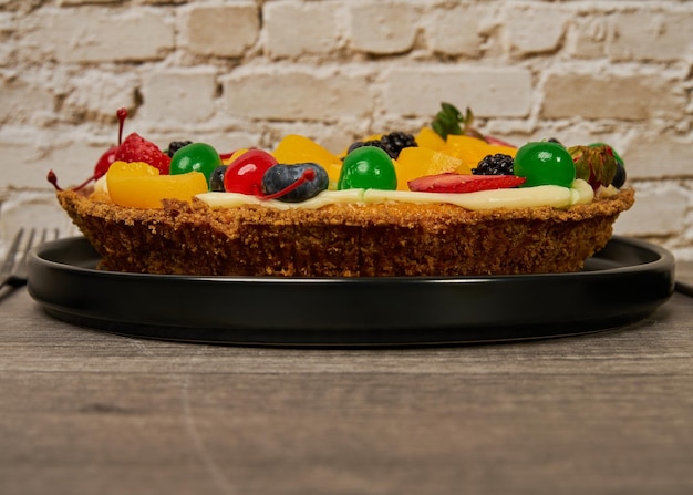 Pastel de frutas con fresas, arándanos, cerezas y duraznos vista lateral