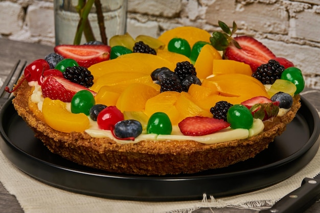 Foto pastel de frutas con fresas, arándanos, cerezas y duraznos vista lateral