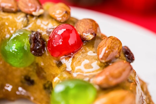 Foto pastel de frutas de navidad cubierto con almendras y cerezas glaseadas