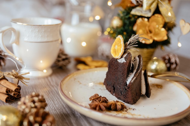 Pastel de frutas de Navidad, pudín en un plato blanco. Decoración navideña. De cerca.