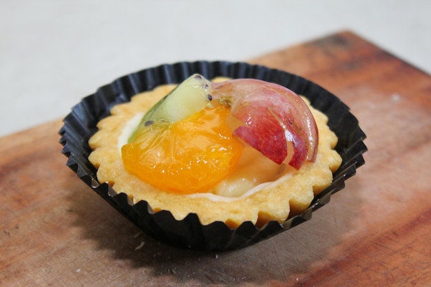 Pastel de frutas plato de postre saludable con relleno de queso crema adornado con uvas kiwi y naranjas