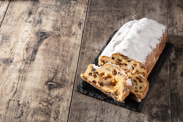 Pastel de frutas stollen de Navidad sobre mesa de madera