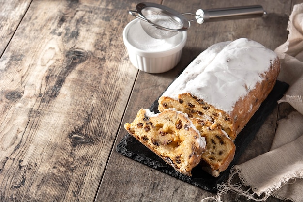 Pastel de frutas stollen de Navidad sobre mesa de madera