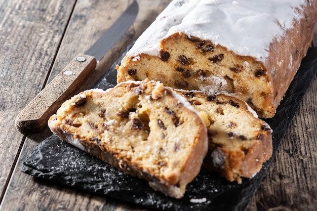 Pastel de frutas stollen de Navidad sobre una mesa de madera