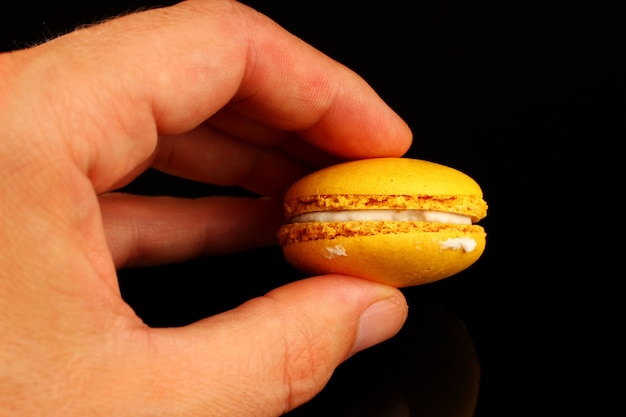 Pastel de galletas de color macarrón en la mano