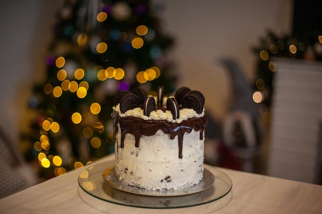 Pastel con galletas negras y con fondo de árbol de navidad desenfocado