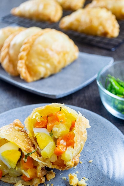 pastel goreng um lanche contendo carne e legumes cozidos por fritura.