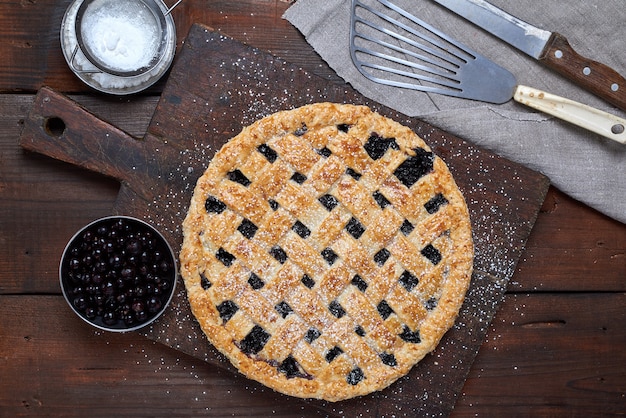 Pastel de grosella negro redondo al horno y en polvo con azúcar glas