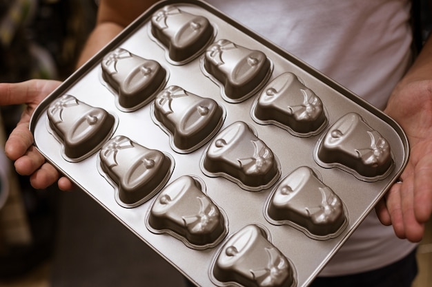 Foto pastel de hierro para galletas y pan de jengibre en manos de un hombre