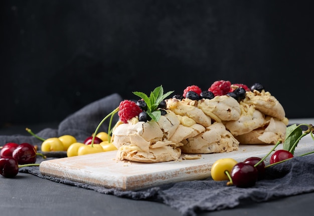 Pastel horneado hecho de proteína de pollo batida y crema decorado con bayas frescas Postre Pavlova