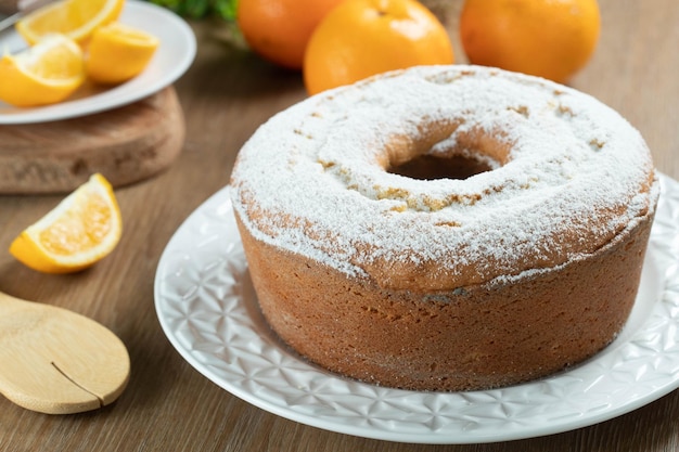 Pastel húmedo de frutas de naranja en un plato con rodajas de naranja en una mesa de madera Delicioso desayuno tradicional inglés Receta de pastel de naranja a la hora del té