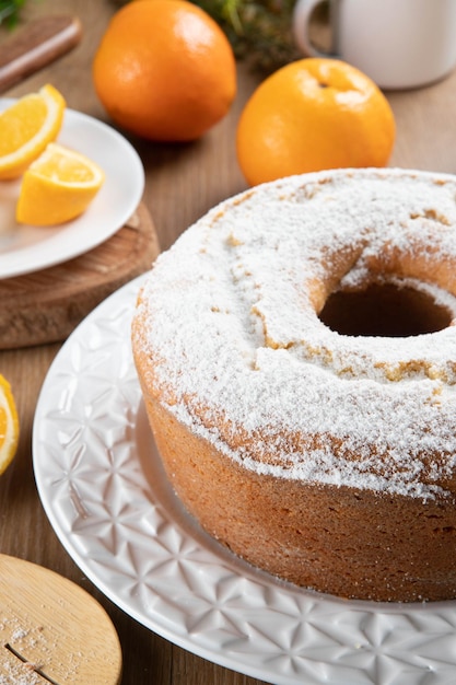 Pastel húmedo de frutas de naranja en un plato con rodajas de naranja en una mesa de madera Delicioso desayuno tradicional inglés Receta de pastel de naranja a la hora del té