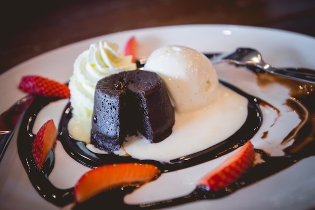 Pastel de lava de chocolate caliente con helado de vainilla y fresas frescas