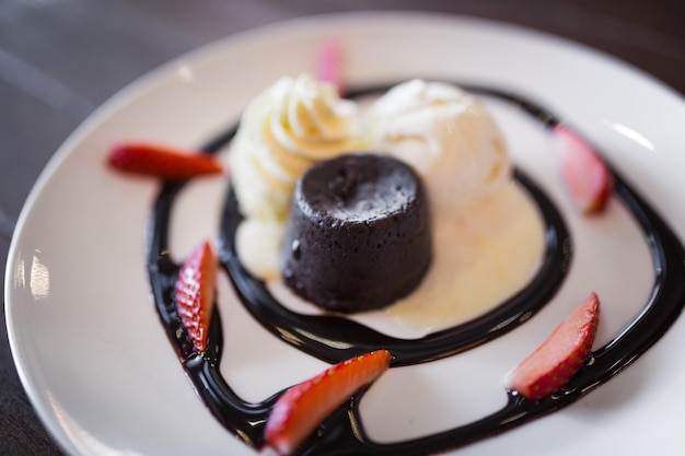 Pastel de lava de chocolate caliente con helado de vainilla y fresas frescas