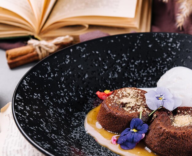 Pastel de lava de chocolate con helado servido en un plato contra una taza de café