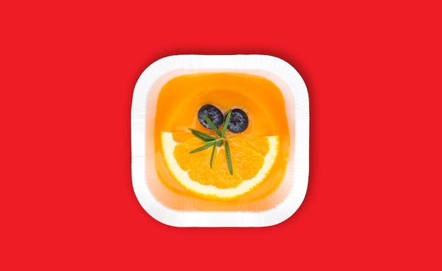 pastel de lava naranja en el centro de la imagen sobre un fondo rojo. Espacio aislado y copia
