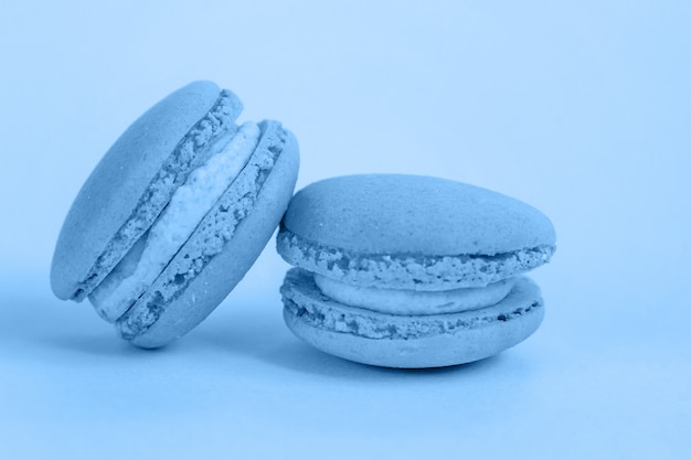 Pastel de macarrón de almendras dulces o macarrones de colores en el color de moda del año 2020 Classic Blue aislado sobre fondo azul pastel. Macro usando color. copyspace