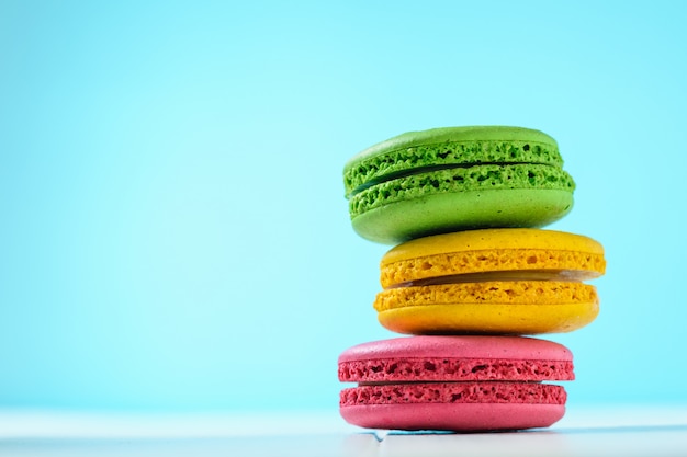 Pastel de macarrón rojo y amarillo y verde sobre una mesa blanca