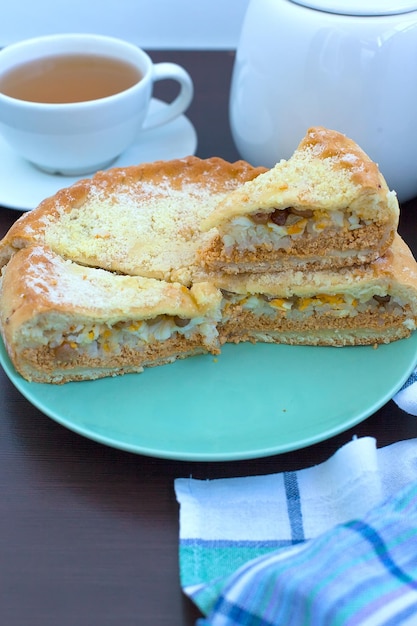 Pastel de mantequilla con relleno de chocolate con almendras y trozos de chocolate sobre una mesa de madera blanca