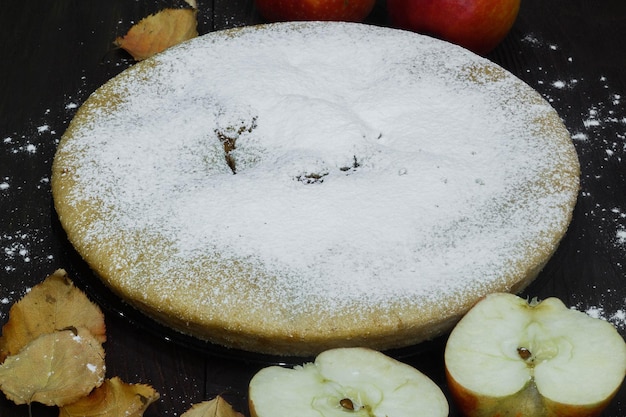 Pastel de manzana casero sobre fondo de madera marrón humor otoñal hojas y manzanas