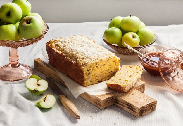 Pastel de manzana y coco y manzanas en un jarrón sobre una mesa