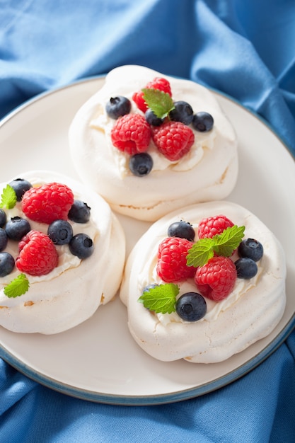 Pastel de merengue pavlova con crema y bayas