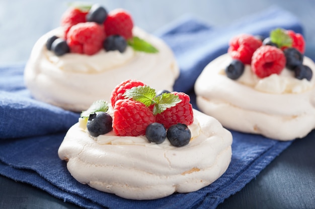 Pastel de merengue pavlova con crema y bayas