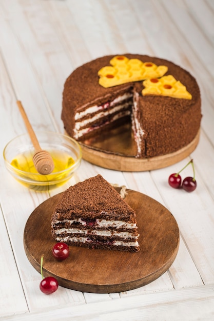 Pastel de miel con cerezas en una madera blanca