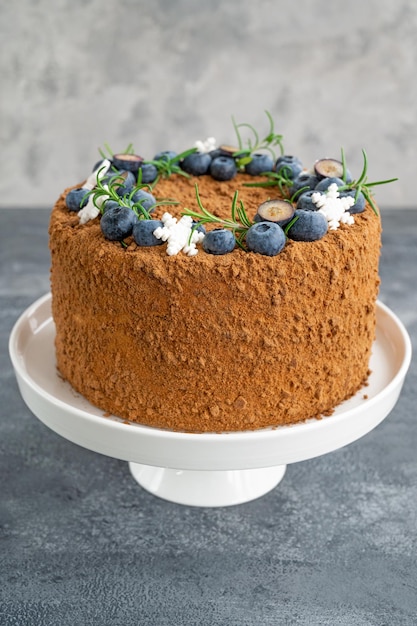 Pastel de miel de chocolate decorado con arándanos, romero y copos de nieve de azúcar Pastel para Navidad