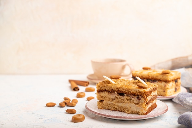 Pastel de miel con crema de leche, caramelo, almendras y una taza de café