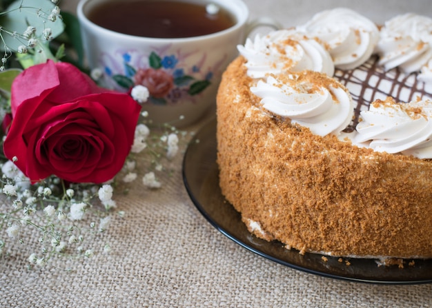 Pastel de miel con flores y té sobre la mesa