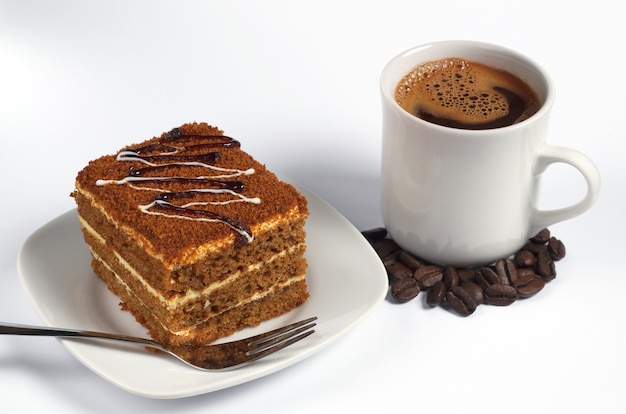 Pastel de miel y taza de café en blanco