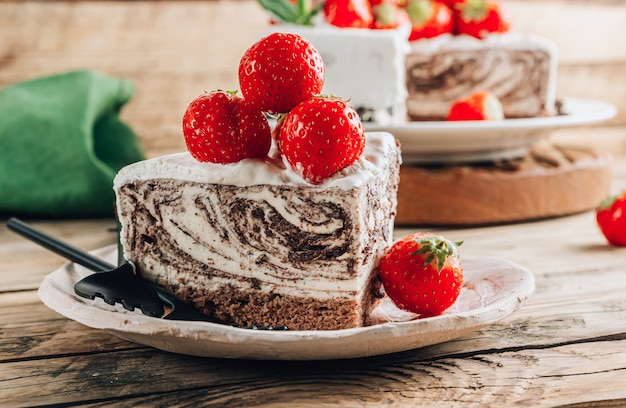 Pastel de mousse de cebra de chocolate con fresa sobre fondo rústico de madera