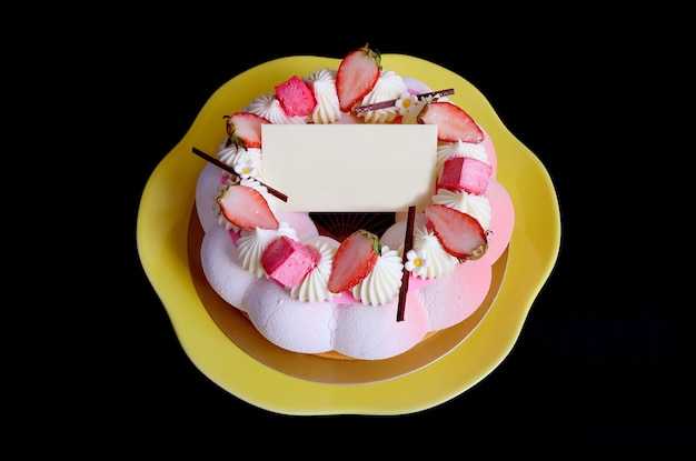 Pastel de mousse de vainilla y gelatina de fresa con tarjeta de felicitación de chocolate blanco en blanco sobre negro