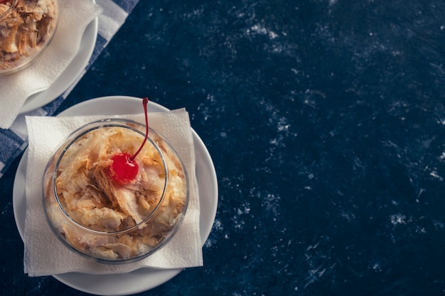 Pastel de Napoleón en un bol de vidrio. Postre dulce. Foto tonificada. Espacio para texto.