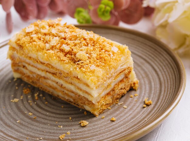 Pastel de Napoleón en un plato en el primer plano de la mesa