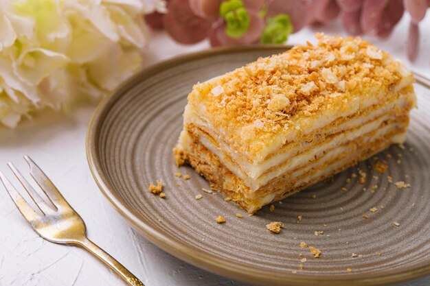 Pastel de Napoleón en un plato en el primer plano de la mesa