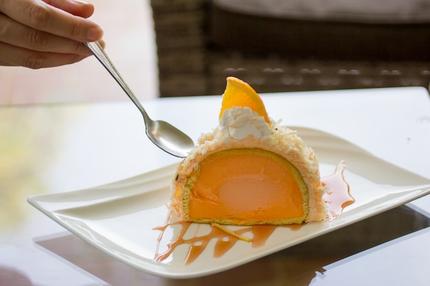 Pastel de naranja, helado de naranja en un plato.