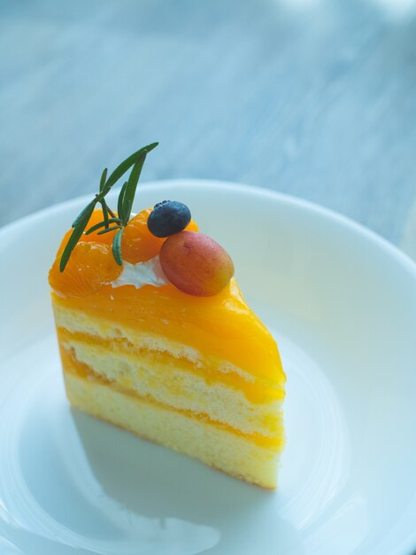 Pastel de naranja con topping, mezcla de frutas en un plato blanco