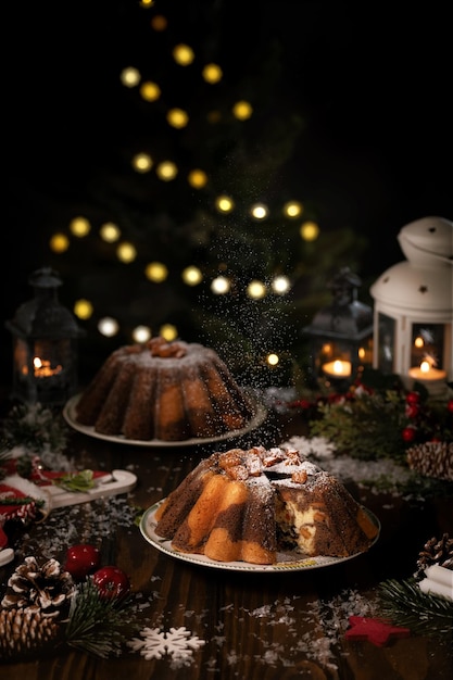 Foto pastel de navidad de chocolate casero tradicional con frutas confitadas de naranja espolvoreadas con azúcar glas. fondo de luces bokeh