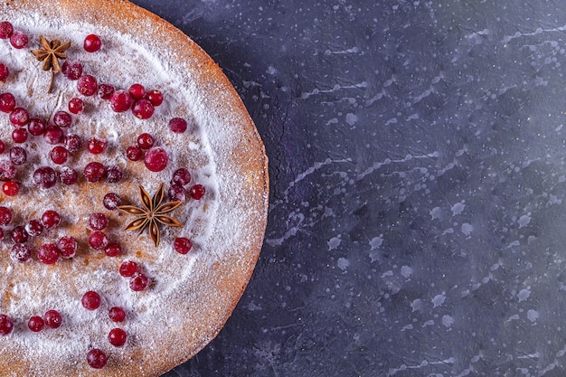 Pastel de Navidad decorado con azúcar en polvo y arándanos.