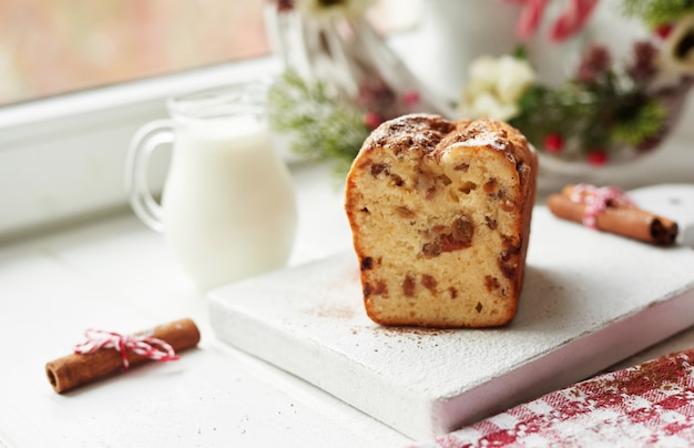 Pastel de Navidad, leche, canela sobre un blanco junto a la ventana