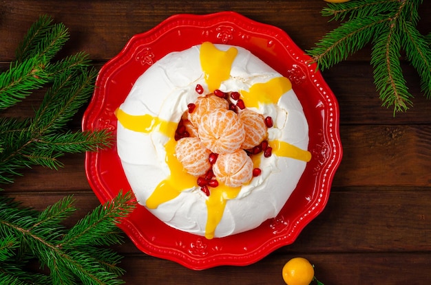 Pastel de Navidad Pavlova con crema batida, mandarinas y granada. Copiar espacio.