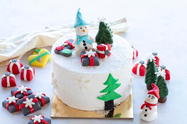 Pastel de Navidad preparado con pasta de azúcar Con árbol de Navidad muñeco de nieve y figuras de regalo en él